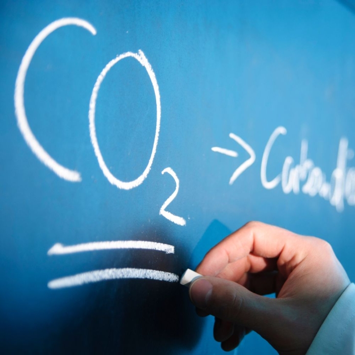 Teaching writing "CO2" on blackboard with chalk