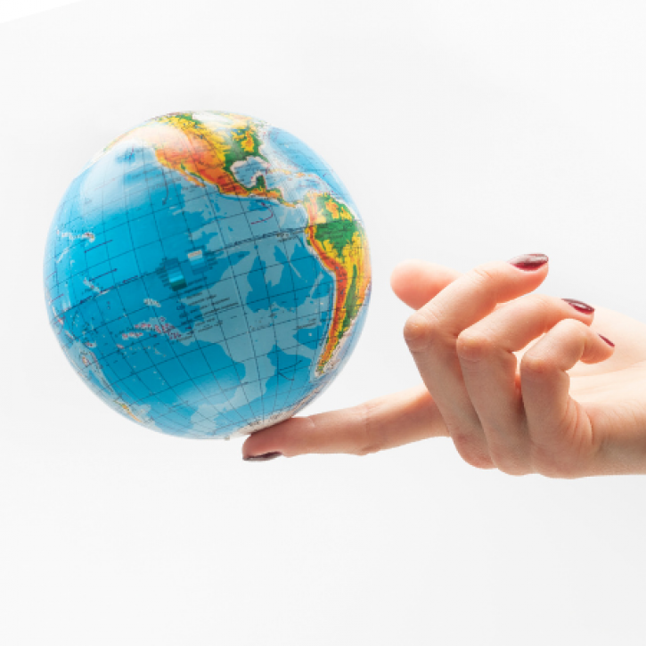 a tipping globe rests on a finger